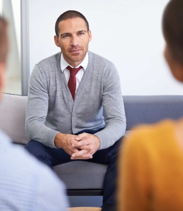 adult-man-sitting-on-sofa-with-clasped-hands-2026-03-25-03-33-41-utc (1)